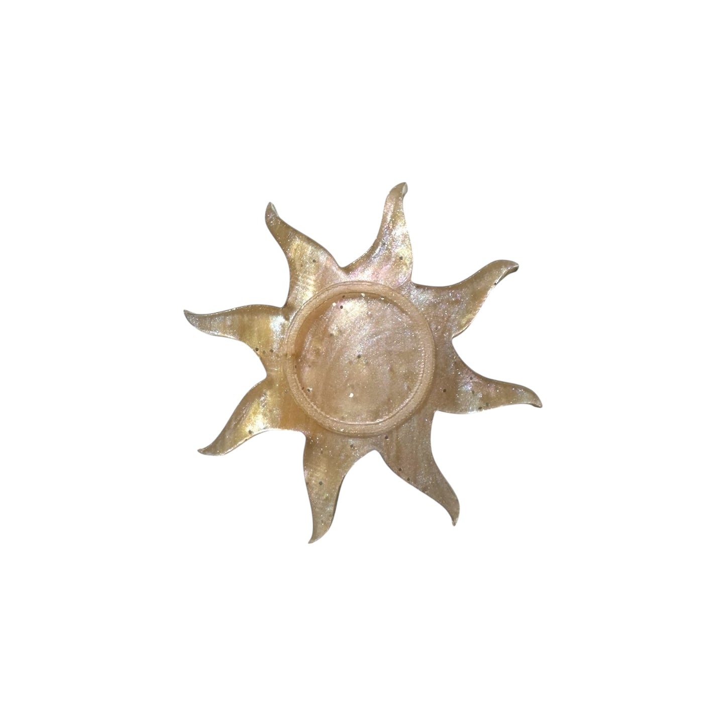 Gold sun-shaped pin on a white background