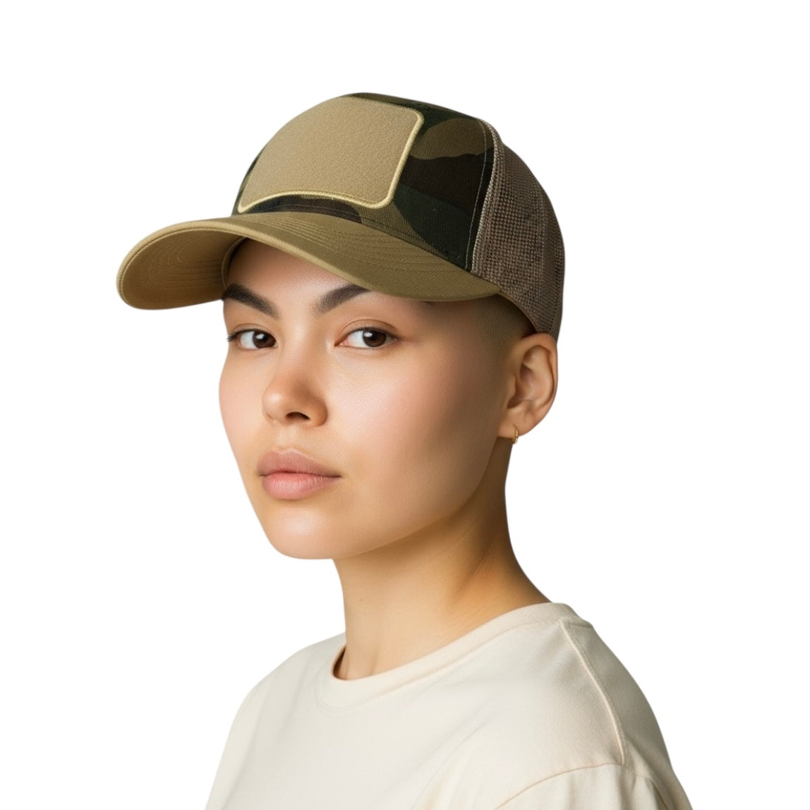 Person wearing a beige and camo trucker hat on a white background.


