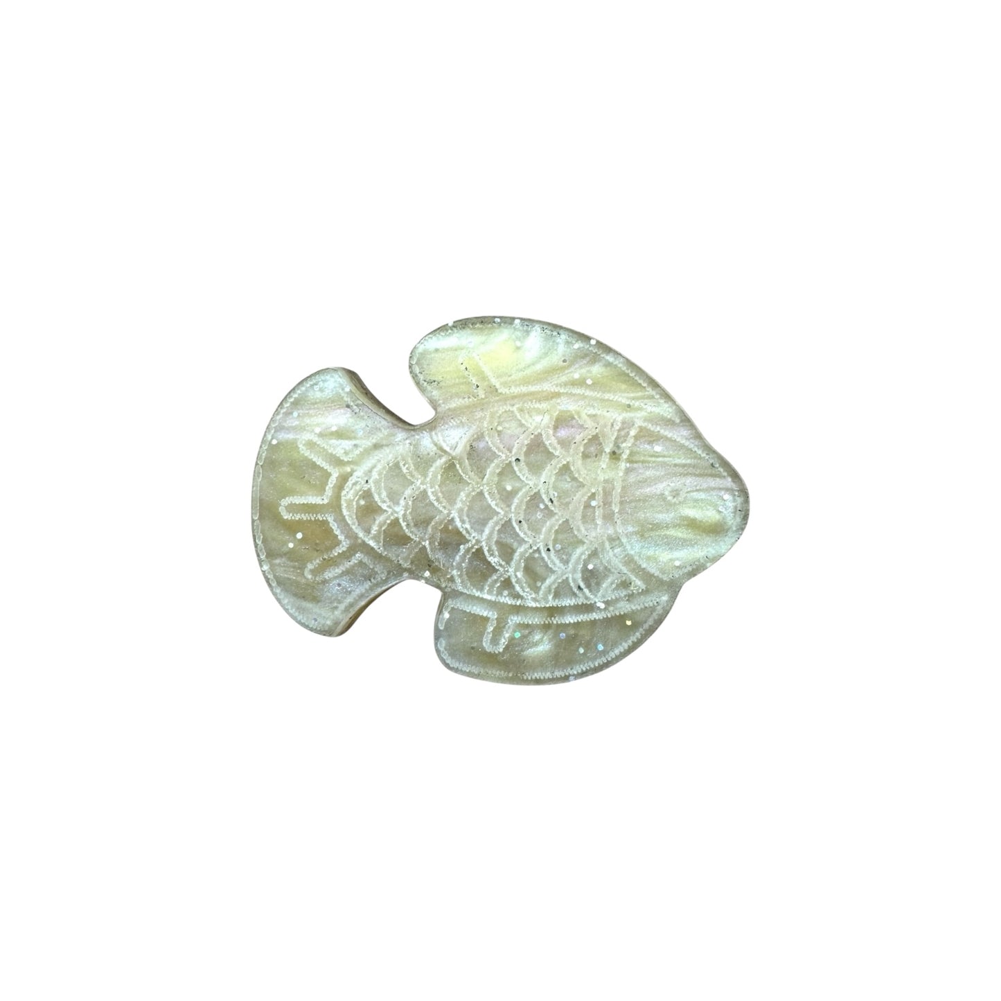 Gold colored gold fish pin on a white background